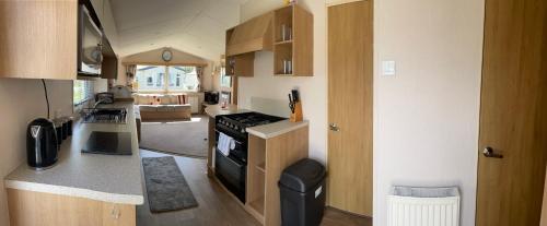 a kitchen with a stove top oven in a tiny house at Beautiful Butlins van in Lincolnshire