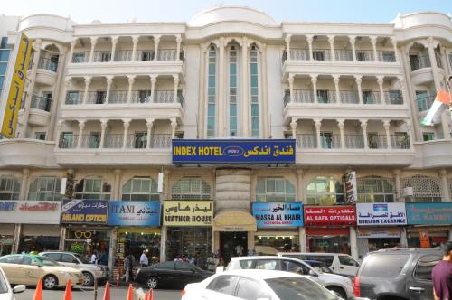 a large building with cars parked in front of it at Index Hotel in Dubai