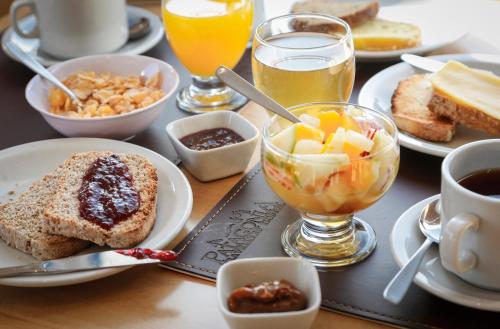 een tafel met borden vol ontbijtproducten en drankjes bij Patagonia Hostel in El Chalten