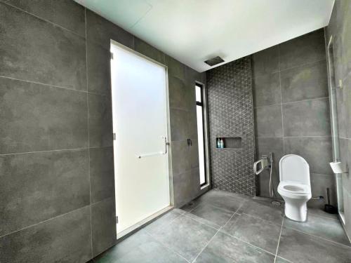 a bathroom with a toilet and a large window at Ezu Isle Langkawi Pool Villa in Pantai Cenang