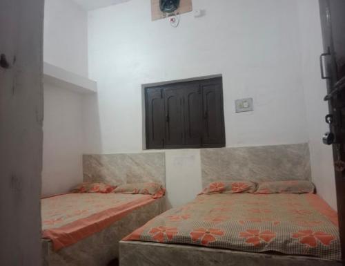 a bedroom with two beds and a cabinet on the wall at Indian Family Lodge, Rajnandgaon, Chhattisgarh in Dongargarh