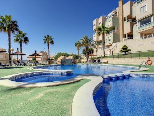 uma piscina num resort com palmeiras e edifícios em Cala Azul -7909 em Cabo de Palos