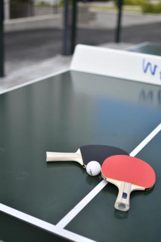 a ping pong racket and ball on a table at Soihtu Stay in Jyväskylä