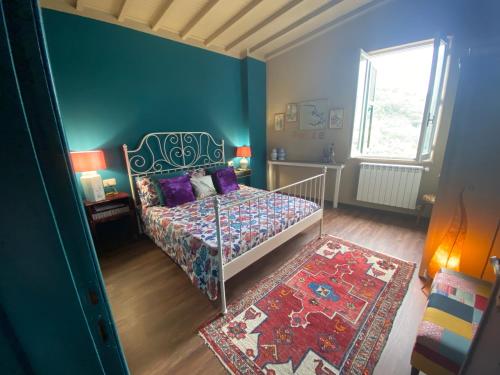 a bedroom with a bed and a blue wall at La MAGIA NEL BORGO in Fezzano