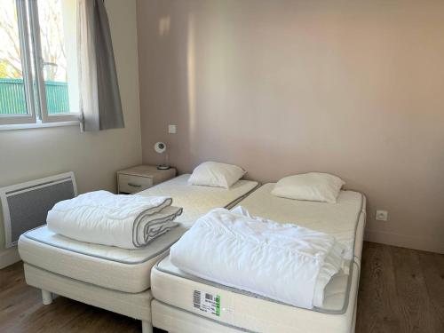 two twin beds in a room with a window at T1 bis confortable avec parking et animaux acceptés - FR-1-495-111 in Cambo-les-Bains