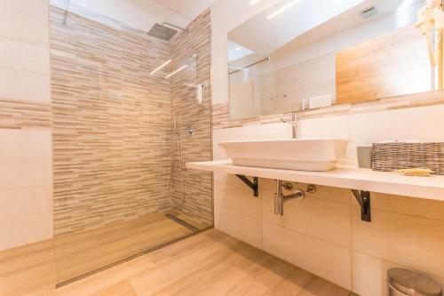 a bathroom with a sink and a shower at Hotel Delfin Lanterna in Tar
