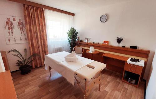 een kamer met een tafel en een bureau met een klok bij HOTEL SVRATKA in Svratka