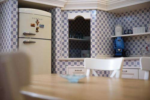 a kitchen with a table and a refrigerator at Palazzo dello Spagnolo Suite in Naples