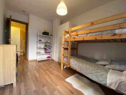 1 dormitorio con 2 literas y suelo de madera en Apartamento El Pueyo de Jaca en El Pueyo de Jaca