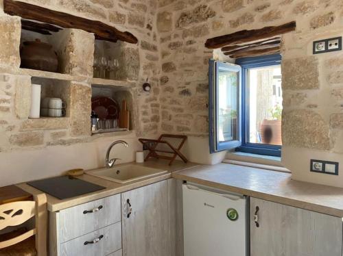 a kitchen with a sink and a window at Little cellar in Chora Folegandros