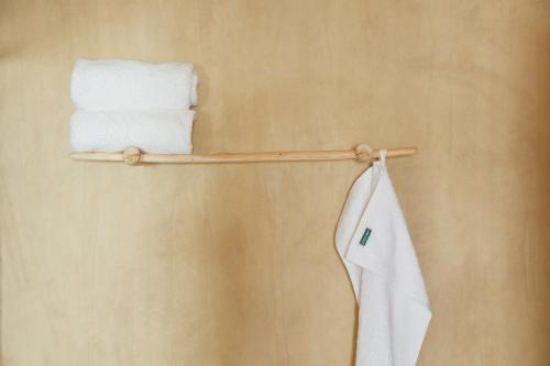 einen Handtuchhalter mit Handtüchern an der Wand in der Unterkunft Plakias Suites COCO-MAT Full Experience in Plakias