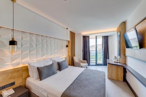Un pat sau paturi într-o cameră la Signature Blue Resort Kuşadası