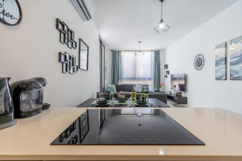 a kitchen with a stove top oven next to a living room at Aziza 1- Bedroom Apartment in Larnaca in Larnaka