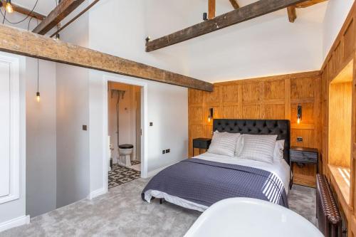 1 dormitorio con 1 cama grande y paredes de madera en Forrester Cottage, Masham, North Yorkshire en Masham