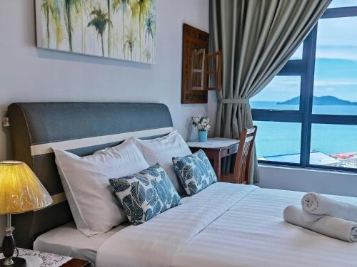 a bedroom with a bed with a view of the ocean at Lavender Homes @ Jesselton Quay Kota Kinabalu in Kota Kinabalu