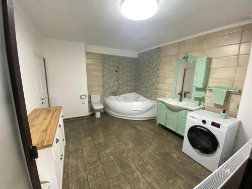 un bagno con vasca e lavatrice di Violetta Apartament a Buzău