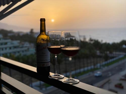 eine Flasche Wein und zwei Gläser auf dem Balkon in der Unterkunft LOFT vistas playa jardin in Puerto de la Cruz