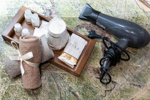 a table topped with a black blow dryer and a box of items at Varese Suites in Varese