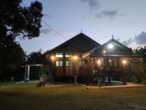 a small house with lights on it at night at Homestay Kampung Den in Kampong Jimah