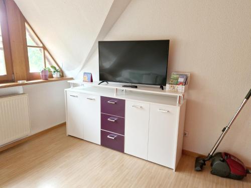 a living room with a tv on a white cabinet at Ferienwohnung Rohlffs Stolpe auf Usedom in Stolpe auf Usedom