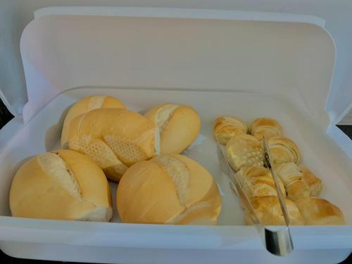 a white container filled with buns and pastries at Pousada Marahub in Maragogi