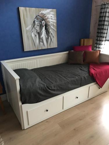 Cama en habitación con pared azul en Trevlig stuga på landet, centralt 8km från Centrum, en Eskilstuna