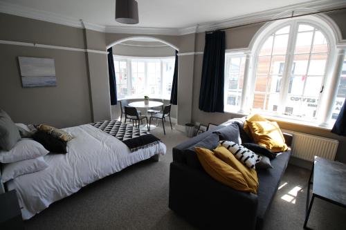 a bedroom with a bed and a couch and a table at Pier View Studio Apartment in Cowes