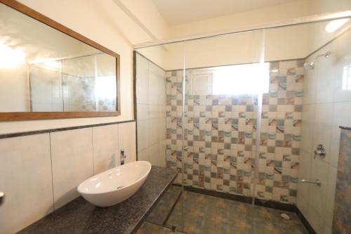 a bathroom with a sink and a shower at VRR Astoria Hotel & Convention Center in Bangalore