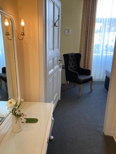 a bathroom with a mirror and a table and a chair at Alte Villa Schlossblick in Bad Pyrmont