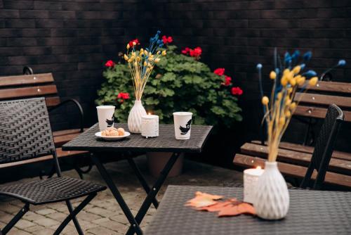 リヴィウにあるNota Bene Loftの花瓶と花が置かれたテーブルと椅子