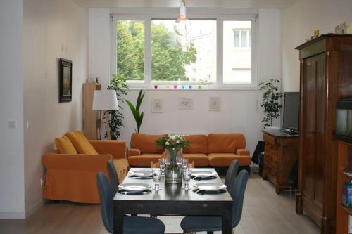 un salon avec une table et un canapé dans l'établissement R-appartements Strasbourg cosy Orangerie pour vos séjours en famille ou entre amis, à Strasbourg