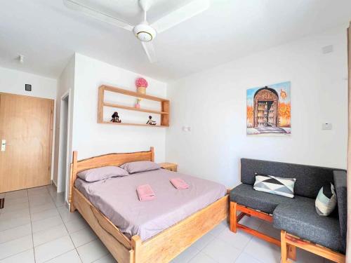 a bedroom with a bed and a bench in it at Homerent @ Fumba-Town in Dambani