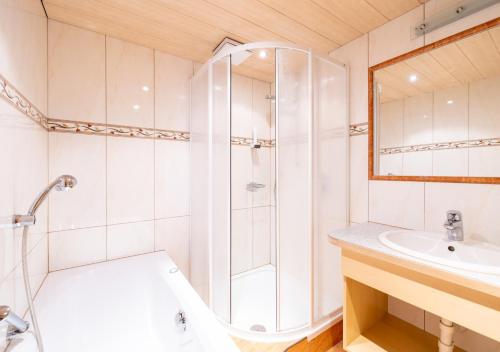 a white bathroom with a shower and a sink at Feriengut Unterhochstätt in Schwendt