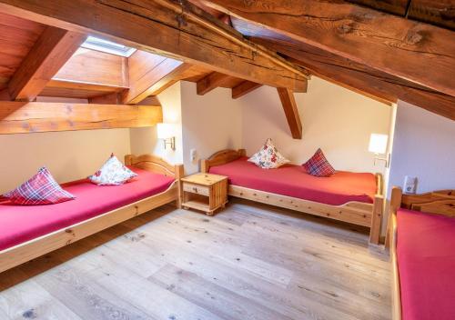 two beds in a room with wooden ceilings at Feriengut Unterhochstätt in Schwendt