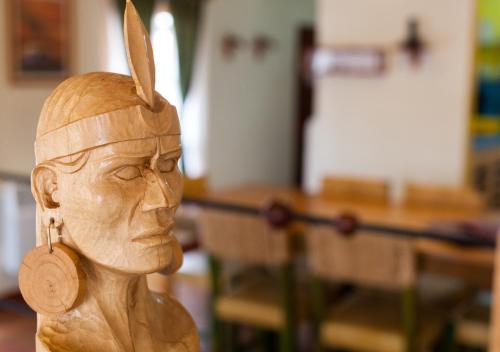 a wooden statue of a woman with a feather on her head at Quinua Boutique Apartments in Cusco