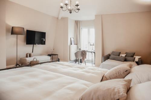 a white room with a bed and a couch at Villa Bosco - Boutiquehotel in Walldorf