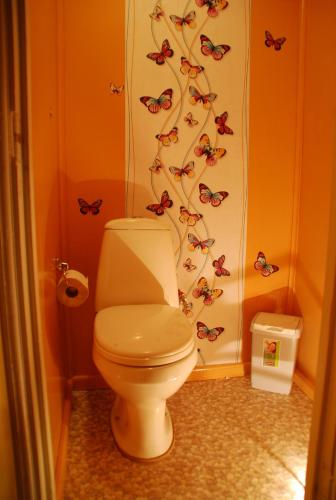 a bathroom with a toilet with butterflies on the wall at Karineeme Holiday House in Mahu