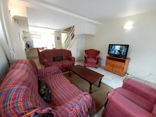 a living room with two couches and a tv at 61 Settler Sands - Beach apartment in Port Alfred