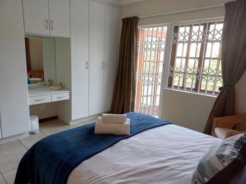a bedroom with a bed with a towel on it at 61 Settler Sands - Beach apartment in Port Alfred