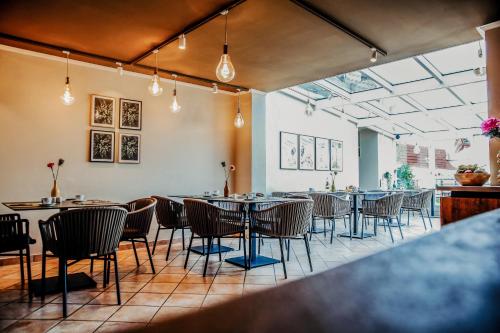 a restaurant with tables and chairs in a room at Villa Bosco - Digitales Boutiquehotel in Walldorf