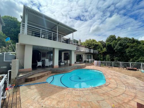 a house with a large swimming pool in front of it at Winston House in Durban