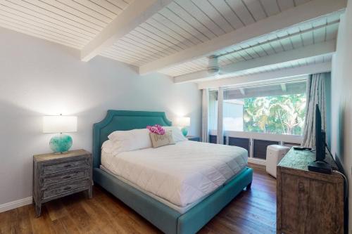 1 dormitorio con cama, ventana y TV en Pali Ke Kua 13, en Princeville
