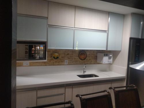 a kitchen with white cabinets and a sink at CASA EM ÓTIMO CONDOMINIO DE BUZIOS in Búzios