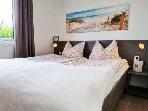 ein Schlafzimmer mit einem großen weißen Bett mit Kissen in der Unterkunft Chalet Serooskerke SE09 in Serooskerke