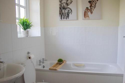 Baño blanco con bañera y lavamanos en Lovely 3-bedroom apartment in Colchester, en Colchester