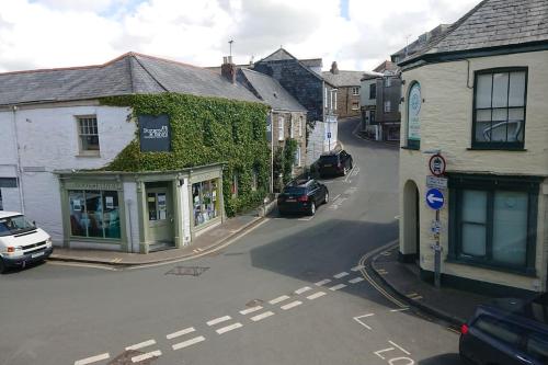 a small town with cars parked on a street at Grocer John's. The heart of the old town in Padstow