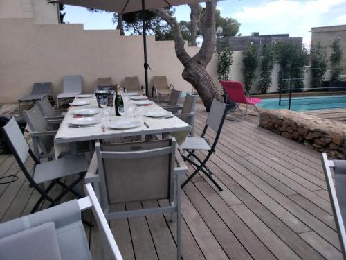 - une table avec des chaises et un parasol sur une terrasse dans l'établissement Villa Saint Clair, à Sète