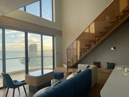 ハロンにあるCitadine Ha Long luxury (Ocean View)のリビングルーム(青いソファ、階段付)