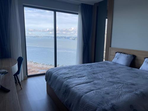 a bedroom with a large bed and a large window at Citadine Ha Long luxury (Ocean View) in Ha Long
