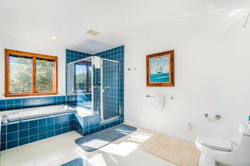 a blue tiled bathroom with a tub and a toilet at Hidden Gem in Arcadia